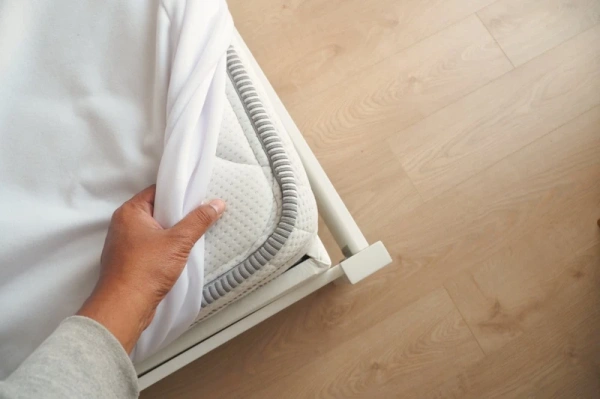 placing-the-white-sheet-on-the-mattress-for-added--urt2rlb_opt